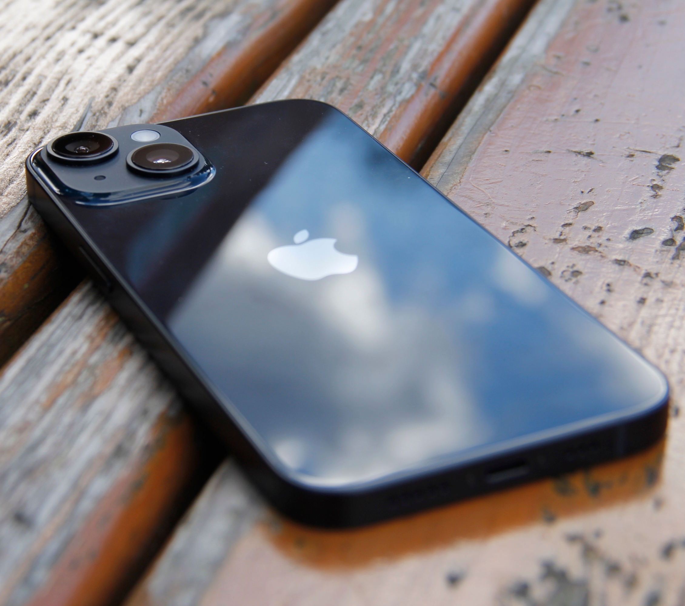 Schwarzes Apple iPhone 14 auf braunen, hölzernen Untergrund