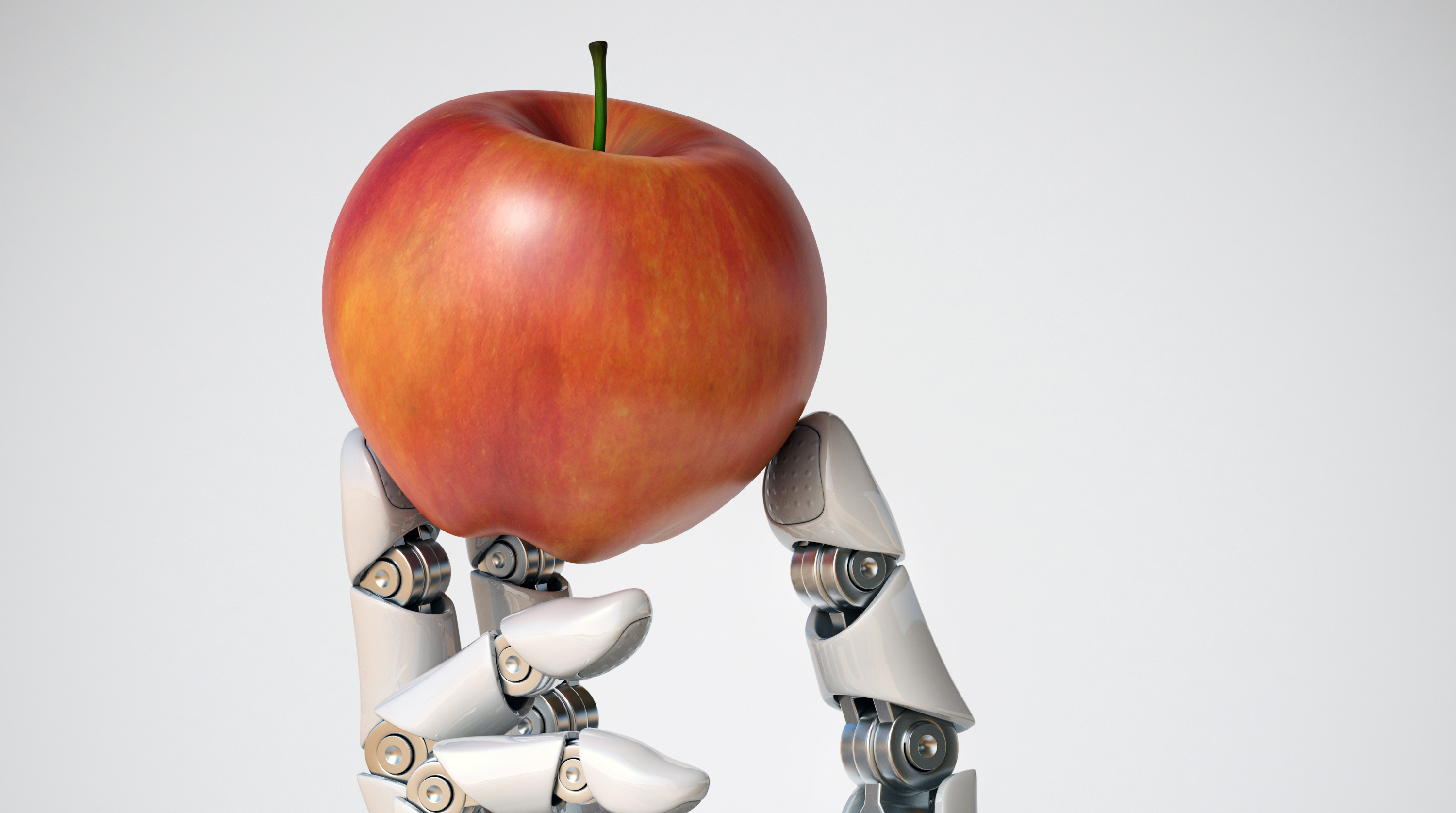 Ein Apfel wird von einem weißen Roboter in der Hand gehalten