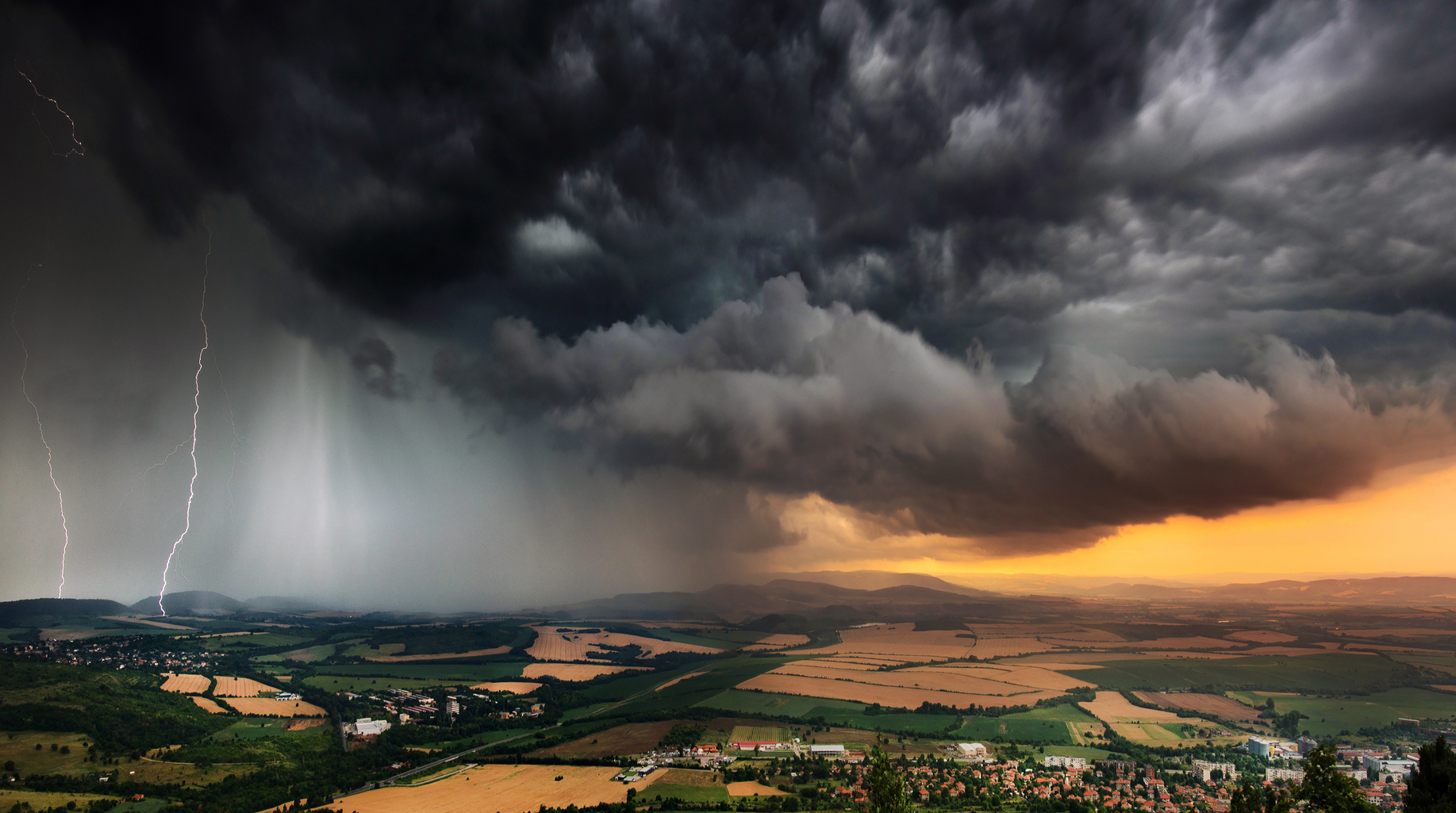 Dunkle Gewitterwolken über ländlicher Landschaft