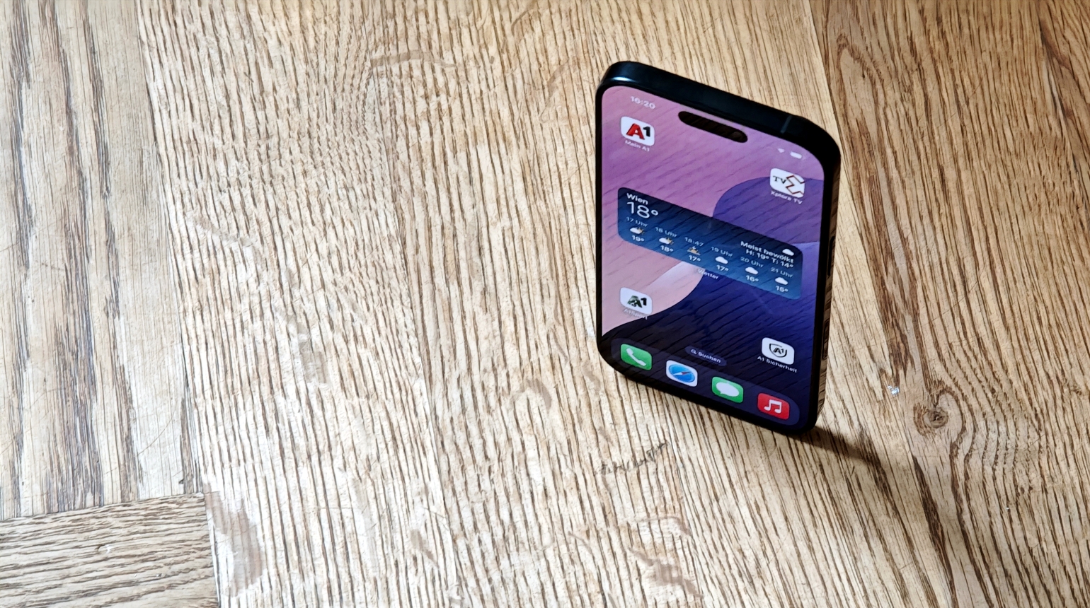 iPhone 16 Pro stehend auf Holzboden
