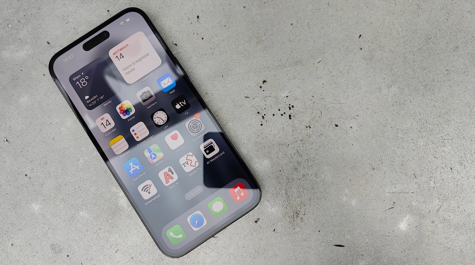 iPhone 14 mit Homescreen auf graumen Hintergrund